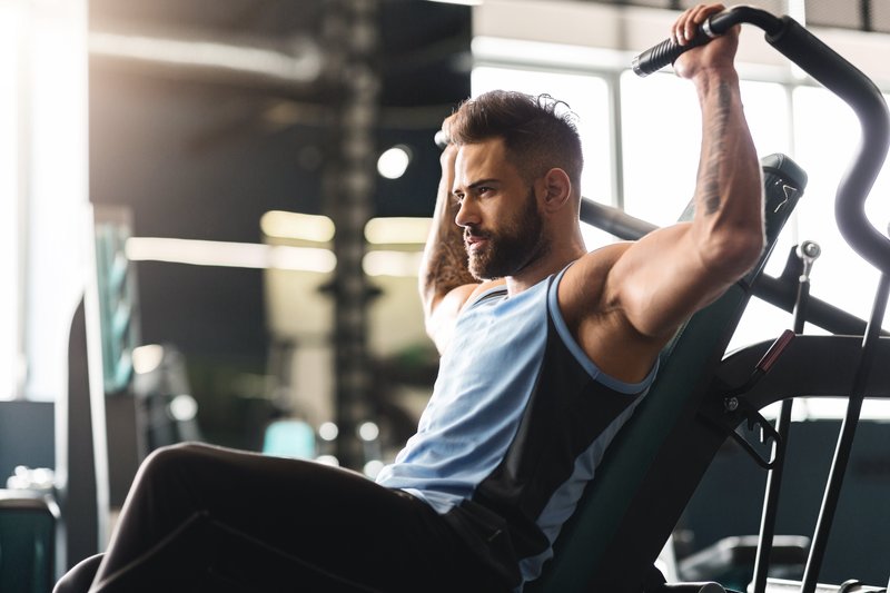 Mann trainiert im Fitnessstudio seine Arme